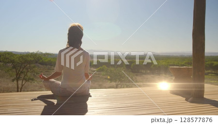 Image of light spots over caucasian woman practicing yoga and meditating 128577876