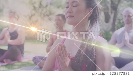 Image of light spots over diverse women practicing yoga and meditating 128577881