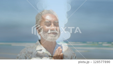 Image of light spots over senior biracial man practicing yoga and meditating Image of light spots over senior biracial man practicing yoga and meditating 128577890