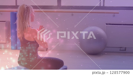 Image of light spots over caucasian woman practicing yoga and meditating Image of light spots over caucasian woman practicing yoga and meditating 128577900