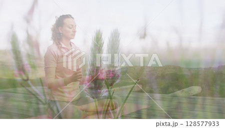 Image of landscape over caucasian woman practicing yoga and meditating Image of landscape over caucasian woman practicing yoga and meditating 128577933