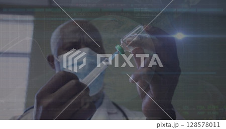 Image of data processing over african american male doctor with face mask with vaccine Image of data processing over african american male doctor with face mask with vaccine 128578011