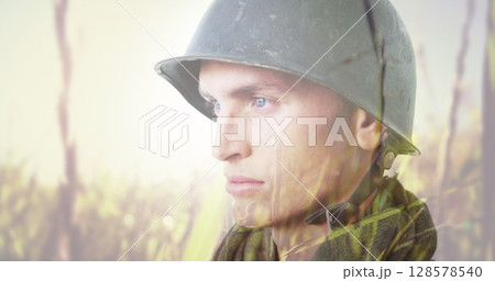 Image of caucasian soldier in helmet over meadow background 128578540