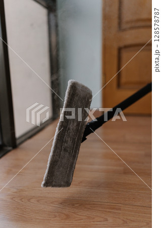 Close-up of steam mop releasing hot vapor during cleaning wooden floors, ensuring efficient and hygienic sanitization for spotless and germ-free home environment. Concept of hygiene and cleanliness. 128578787
