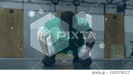Image of medical and health icons over caucasian man exercising in gym with weights Image of medical and health icons over caucasian man exercising in gym with weights 128579227