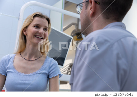 Engaging Interaction Between a Patient and Dentist in a Modern Dental Clinic Setting Focused on Building Trust and Comfort for Dental Care and Treatment Consultation 128579543