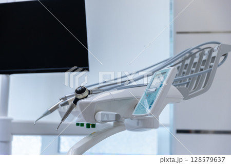 Modern Dental Equipment with a Focus on Precision Tools and a Sleek Monitor Displaying White Space for Patient Comfort in a Clean Office Environment 128579637
