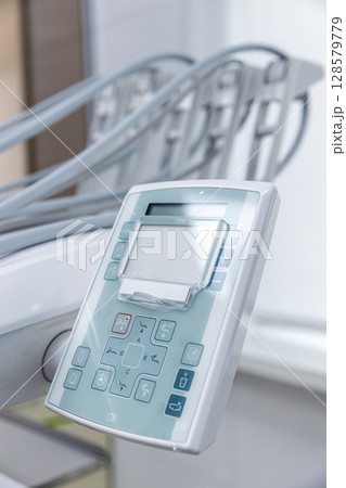 Modern Dental Equipment Control Panel with Various Functions for Patient Comfort and Efficient Dental Procedures in a Bright Clinical Environment 128579779
