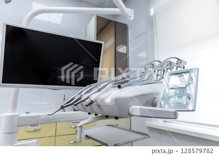 Modern Dental Clinic Equipment Featuring an Advanced Dental Chair and Monitor for Enhanced Patient Experience and Efficient Dental Procedures in a Sleek Environment 128579782