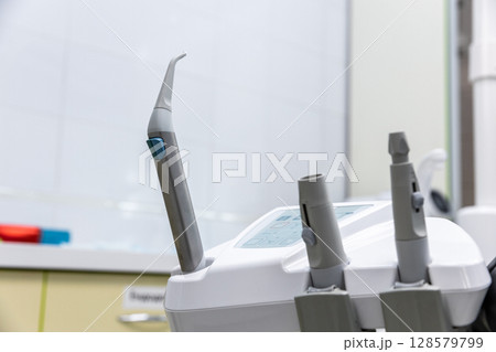 Advanced Dental Equipment in a Modern Clinic Setting, Featuring a Close-Up of an Innovative Dental Handpiece for Professional Oral Care Procedures Advanced Dental Equipment in a Modern Clinic Setting, Featuring a Close-Up of an Innovative Dental Handpiece for Professional Oral Care Procedures 128579799