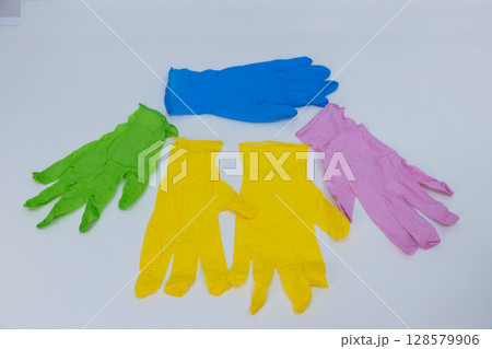 A Vibrant Collection of Colorful Rubber Gloves Arranged Neatly on a White Surface, Showcasing a Mix of Colors for Various Cleaning and Protective Uses 128579906