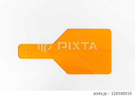 A Bright Orange Paddle Tool Against a White Background: Practical Uses in Various Applications Including Cooking, Art, and Educational Settings 128580010