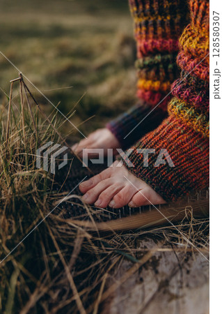 Bare feet in knitted leg warmers standing on nails over grass, symbolizing yoga practice, meditation, pain tolerance, and overcoming fear. A powerful image of mental strength and body awareness 128580307