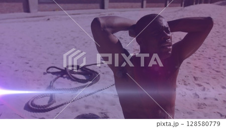 Image of glowing lights over an exercising african american man Image of glowing lights over an exercising african american man 128580779