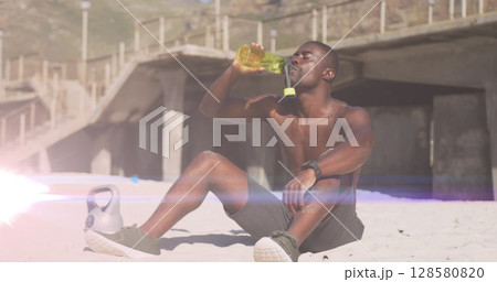 Image of glowing lights over an exercising african american man drinking water 128580820