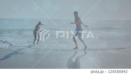 Image of stars over caucasian couple having fun on beach 128580842
