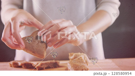 Image of hearts over hands of caucasian woman holding cookies Image of hearts over hands of caucasian woman holding cookies 128580954