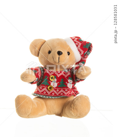 Cute plush teddy bear wearing a red Christmas sweater and Santa hat, sitting on white background Cute plush teddy bear wearing a red Christmas sweater and Santa hat, sitting on white background 128581031