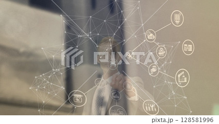 Image of network of connections with icons over caucasian businessman 128581996