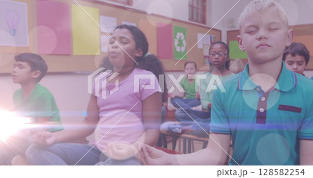 Image of lights over diverse pupils practicing yoga at school 128582254