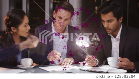 Image of network of connections with icons over diverse businesspeople in office 128582284