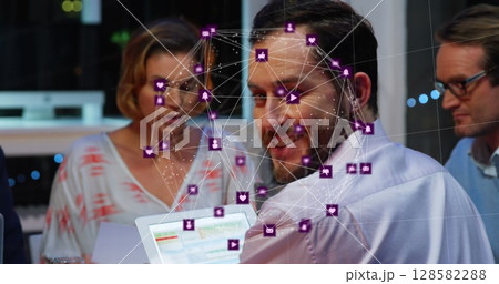 Image of network of connections with icons over diverse businesspeople in office 128582288