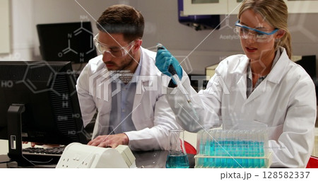 Image of scientific data over caucasian female and male lab workers with samples Image of scientific data over caucasian female and male lab workers with samples 128582337