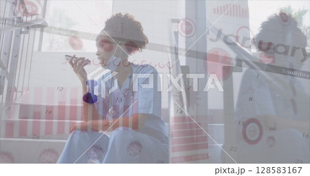 Image of virus cells and graphs over african american male doctor using tablet 128583167