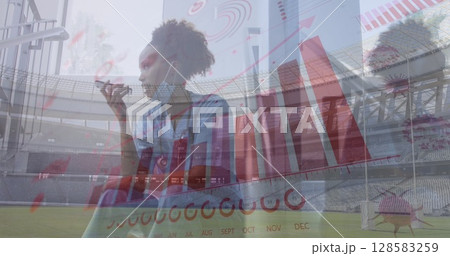 Image of financial data and virus cells over african american doctor using smartphone 128583259