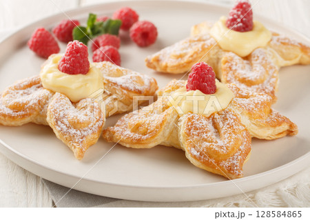 Delicious summer puff pastry with vanilla custard and fresh raspberries close-up in a plate. Horizontal 128584865