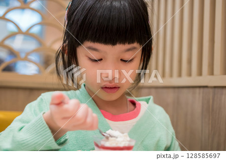 Cute little asian child girl eating food Cute little asian child girl eating food 128585697