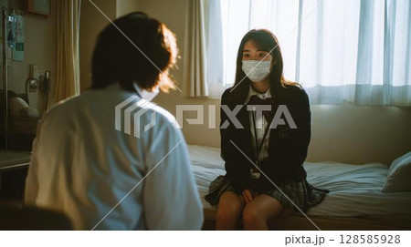 体調不良で学校の保健室を訪れた制服姿の女子生徒 128585928
