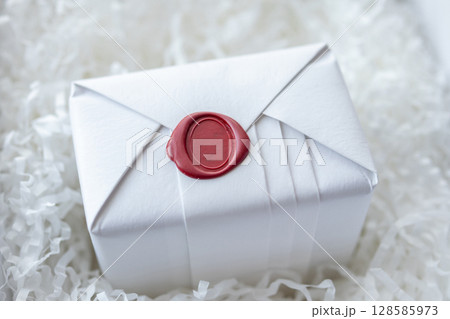 Wax seal stamp on white paper wrap packaging parcel box 128585973