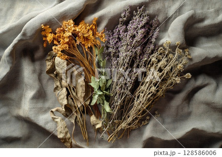 Vibrant Herbs and Dried Flowers Arranged on a Textured Gray-Brown Fabric. Generative AI 128586006