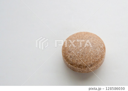 Brown herbal pill tablet on white background Brown herbal pill tablet on white background 128586030