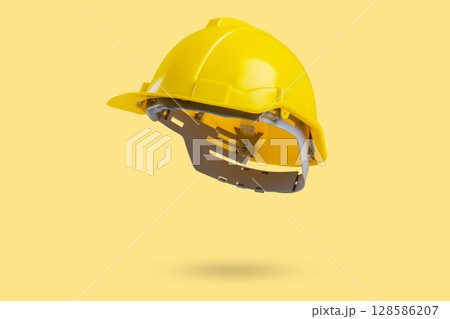 Safety construction helmet on yellow background 128586207