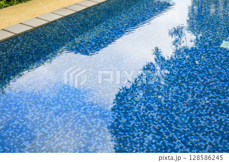 Swimming pool water surface and ripple wave with blue mosaic tiles Swimming pool water surface and ripple wave with blue mosaic tiles 128586245