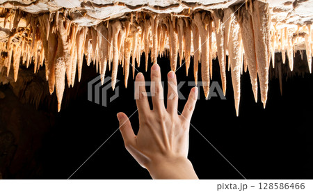 Hand Touching Cave Stalactites 128586466
