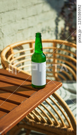 Blank-labeled beer bottle on outdoor sunny table for advertisement mockup Blank-labeled beer bottle on outdoor sunny table for advertisement mockup 128586992