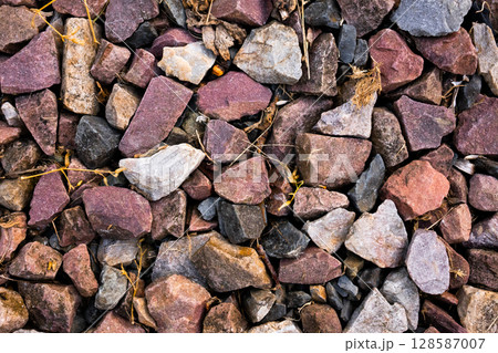 Multicolored gravel rocks with mixed textures and natural patterns Multicolored gravel rocks with mixed textures and natural patterns 128587007