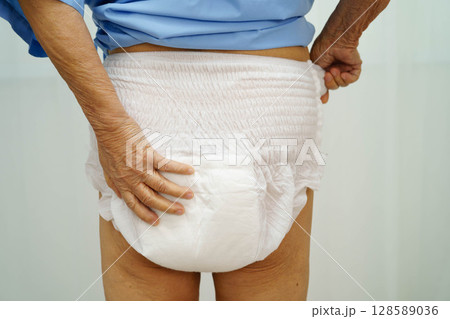 Asian senior woman patient wearing adult incontinence diaper pad in hospital. Asian senior woman patient wearing adult incontinence diaper pad in hospital. 128589036