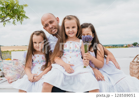 The family is resting on a retro bench in the lavender field 128589051