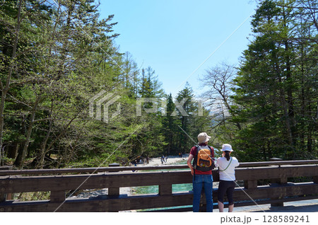夏の観光名所上高地の田代橋の上で風景を楽しむ男女観光客の姿 128589241