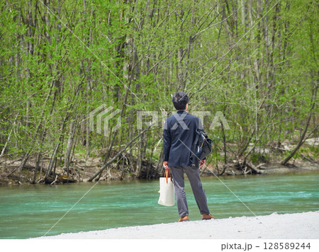 夏の観光名所上高地の梓川の風景を楽しむ男性観光客の姿 128589244
