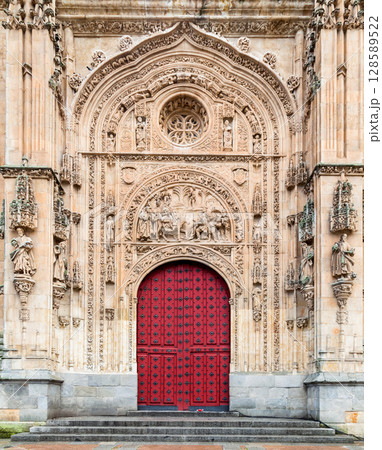 Intricate red door of the historic Cathedral in Salamanca, Spain showcasing detailed carvings 128589522