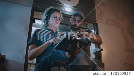 Male Worker and Female Manager Talking, Using Tablet Computer, Standing Outside of Logistics Warehouse Male Worker and Female Manager Talking, Using Tablet Computer, Standing Outside of Logistics Warehouse 128590937