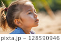 真夏の公園で遊んでいる女の子の横顔 128590946