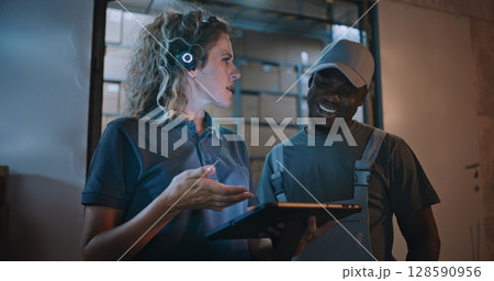 Worker and Female Manager Using Tablet Computer, Standing Outside of Logistics Retail Warehouse Worker and Female Manager Using Tablet Computer, Standing Outside of Logistics Retail Warehouse 128590956