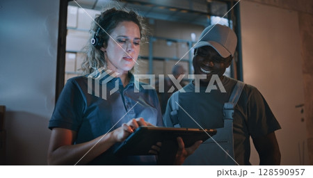 Worker and Female Manager Using Tablet Computer, Standing Outside of Logistics Retail Warehouse Worker and Female Manager Using Tablet Computer, Standing Outside of Logistics Retail Warehouse 128590957