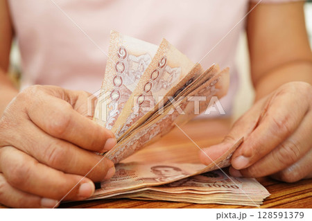 Asian woman counting Thai baht banknote money, investment economy, accounting business and banking. Asian woman counting Thai baht banknote money, investment economy, accounting business and banking. 128591379